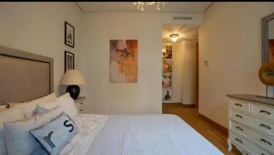 a bedroom with a large white bed and a dresser at Cosy home in Casablanca