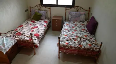 a bedroom with two beds and a window at Le refuge vert in Berrechid