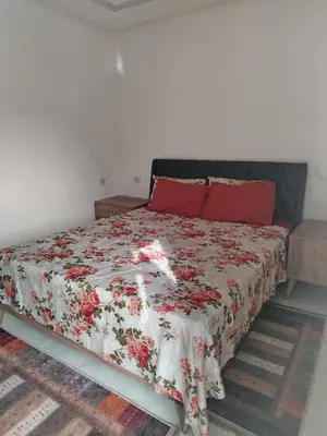 a bedroom with a bed with a floral bedspread at Calme large studio in Casablanca