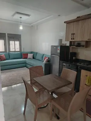 a living room with a couch and a table and chairs at Calme large studio in Casablanca