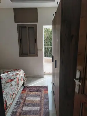 a bedroom with a bed and a door with a window at Calme large studio in Casablanca