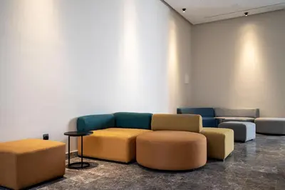 a living room with a couch and two ottools at CFC Modern Studio Emplacement Face à Anfa Park in Casablanca