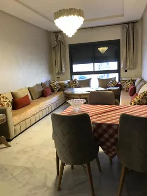 a living room with a couch and a table and chairs at appartement in Mohammedia