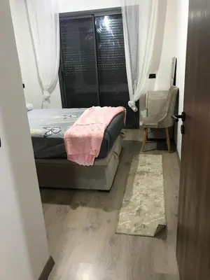 a small bedroom with a bed and a chair at appartement in Mohammedia