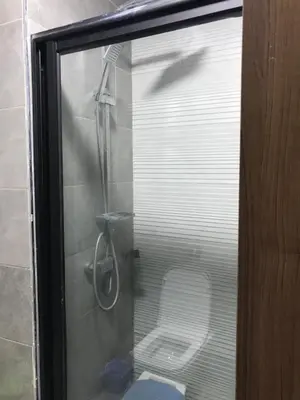 a glass shower with a toilet in a bathroom at appartement in Mohammedia