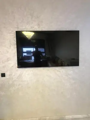 a mirror on a wall with a person in a room at appartement in Mohammedia