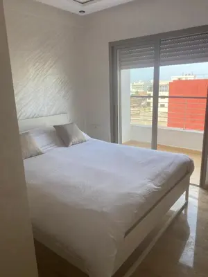 a bedroom with a white bed with a large window at Bright & Cozy Apartment in Casablanca