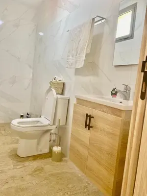 a white bathroom with a toilet and a sink at Bright & Cozy Apartment in Casablanca