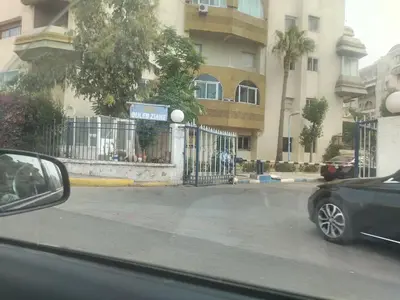a car parked in front of a building with a fence at Très joli appartement à Casablanca in Casablanca