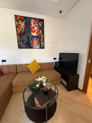 a living room with a couch and a table with a painting at Modern Studio in Hay Riad All Comfort in Rabat