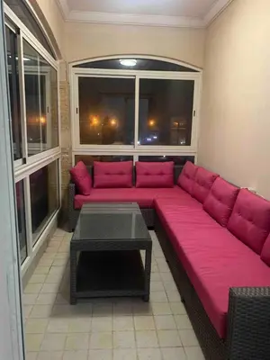 a large pink couch in a room with windows at Lovely three sides Appart in Ola Blanca in Sidi Rahal
