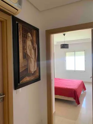 a bedroom with a bed and a painting on the wall at Lovely three sides Appart in Ola Blanca in Sidi Rahal