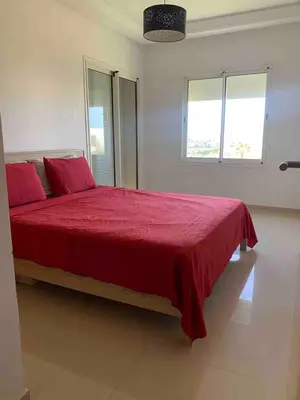 a bedroom with a large bed with a red blanket at Lovely three sides Appart in Ola Blanca in Sidi Rahal