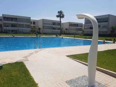 a swan statue in front of a swimming pool at Lovely three sides Appart in Ola Blanca in Sidi Rahal