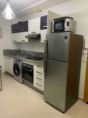 a kitchen with a refrigerator and a microwave on top of it at Lovely three sides Appart in Ola Blanca in Sidi Rahal