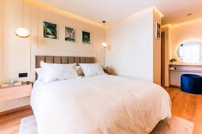 a bedroom with a large white bed with white pillows at Appartement Cosy neuf - Salle de sport in Casablanca