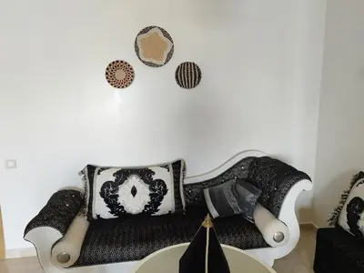 a living room with a black and white couch at Apartment in residence CASABAY in Sidi Rahal