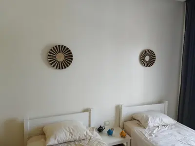 a bedroom with two beds and a mirror on the wall at Apartment in residence CASABAY in Sidi Rahal