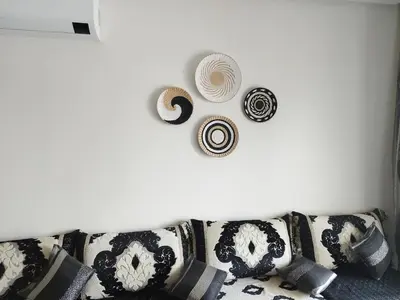 a white wall with a couch with hats on it at Apartment in residence CASABAY in Sidi Rahal
