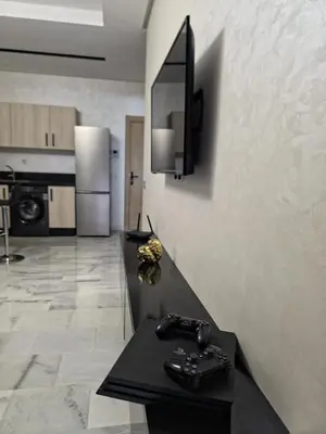 a kitchen with a black counter and a television on a wall at apartment luxe dt7 in Casablanca