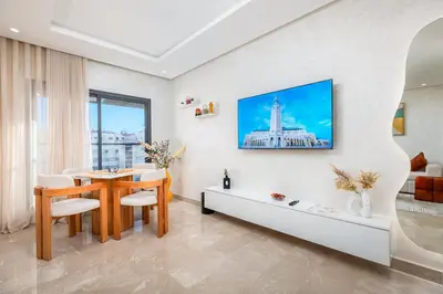 a living room with a dining room table and a building at Modern Comfortable Apartment - Corniche Hassan II in Casablanca