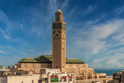 a large building with a clock tower on top of it at Modern Comfortable Apartment - Corniche Hassan II in Casablanca