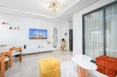 a living room with a table and a chair at Modern Comfortable Apartment - Corniche Hassan II in Casablanca