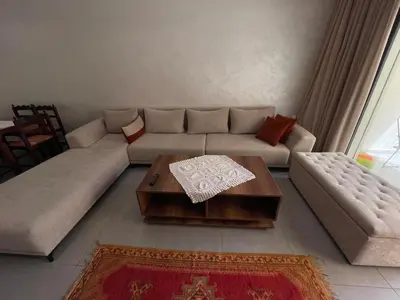 a living room with a couch and a coffee table at Cozy Studio with pool, fiber optics in Mansouria