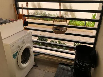 a laundry room with a washing machine and a window at Cozy Studio with pool, fiber optics in Mansouria