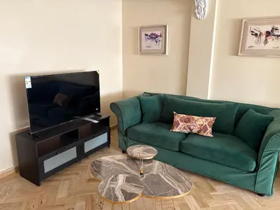 a living room with a green couch and a tv at Casa 2mars Appart lumineux in Casablanca