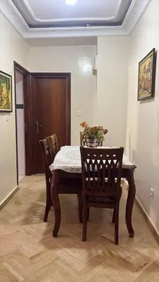 a dining room table and chairs with a table and flowers on it at Casa 2mars Appart lumineux in Casablanca