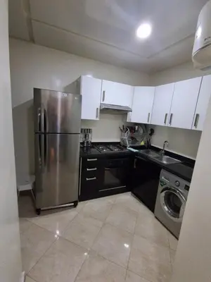 a kitchen with a stainless steel refrigerator and white cabinets at Joli Studio Hôpital Cheikh Khalifa in Casablanca
