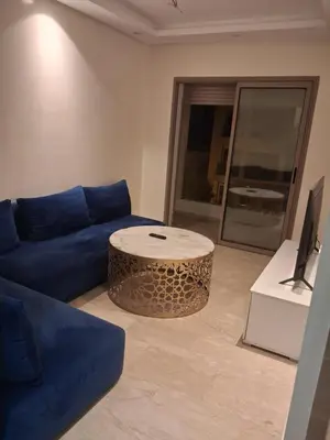 a living room with a blue couch and a table at Joli Studio Hôpital Cheikh Khalifa in Casablanca