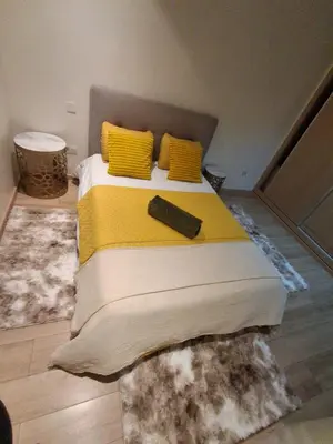 a bed with yellow pillows and a remote control on it at Joli Studio Hôpital Cheikh Khalifa in Casablanca
