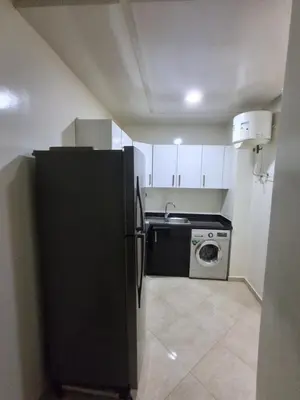 a kitchen with a black refrigerator and a washing machine at Joli Studio Hôpital Cheikh Khalifa in Casablanca