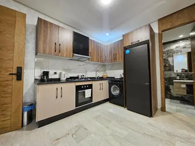 a kitchen with wooden cabinets and a black refrigerator at Casablanca premium Suite,wifi,parking in Casablanca