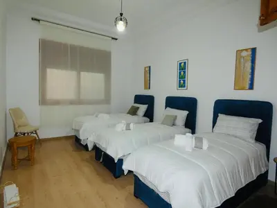 a room with four beds with blue chairs and a window at Appartement meuble rabat in Rabat
