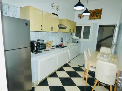 a kitchen with a refrigerator and a table with chairs at Appartement meuble rabat in Rabat