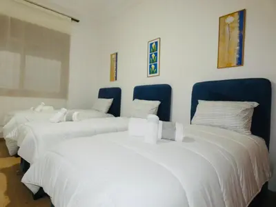 a group of four white beds in a room at Appartement meuble rabat in Rabat