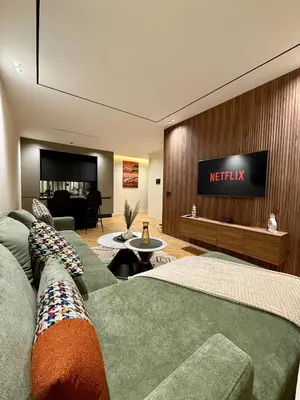 a living room with a couch and a tv on a wall at Cozy Modern Studio Near Stadium Mohammed V in Casablanca