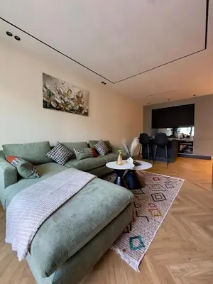 a living room with a green couch and a table at Cozy Modern Studio Near Stadium Mohammed V in Casablanca
