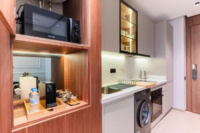 a kitchen with a washing machine and a microwave at Princesses Luxury Studio - Elegance & Light in Casablanca