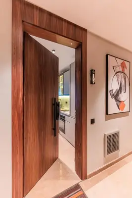a wooden door in a room with a kitchen at Princesses Luxury Studio - Elegance & Light in Casablanca