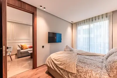 a bedroom with a bed and a tv on a wall at Princesses Luxury Studio - Elegance & Light in Casablanca
