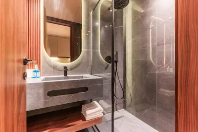 a bathroom with a shower with a sink and a mirror at Princesses Luxury Studio - Elegance & Light in Casablanca