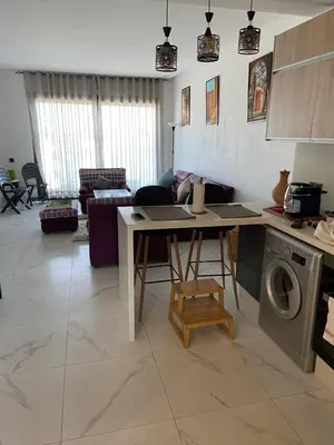 a kitchen and living room with a table and a washing machine at Bright & cozy studio in Oasis, close to train station in Casablanca