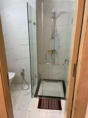 a shower with a glass door in a bathroom at Bright & cozy studio in Oasis, close to train station in Casablanca