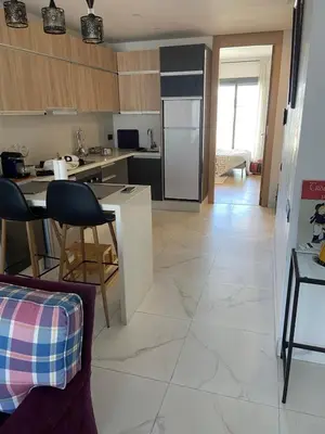a kitchen with a table and some chairs in a room at Bright & cozy studio in Oasis, close to train station in Casablanca