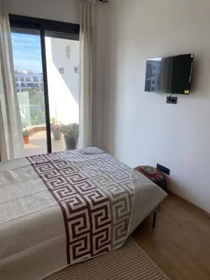 a bedroom with a bed and a flat screen tv at Bright & cozy studio in Oasis, close to train station in Casablanca