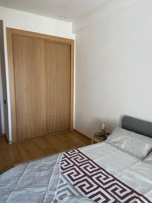 a bedroom with a bed and a wooden closet at Bright & cozy studio in Oasis, close to train station in Casablanca